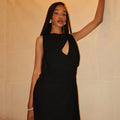 An elegant, sleeveless long dress with a high neck and pleated texture.