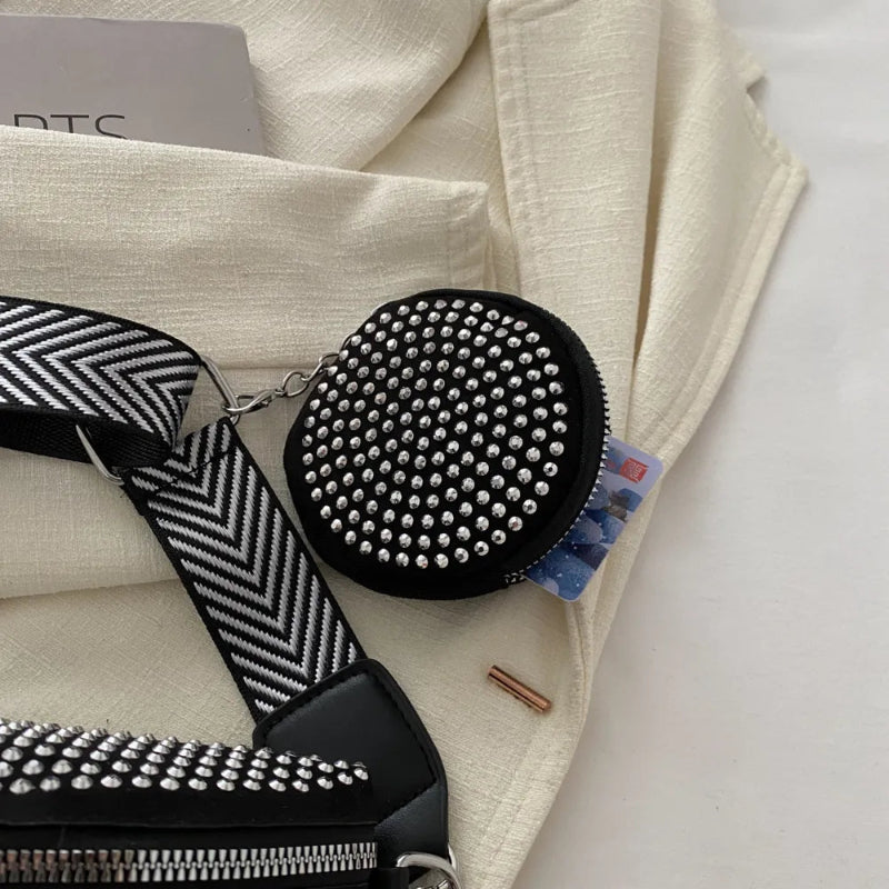 A medium-sized black crossbody bag made of PU material, adorned with metallic studs and featuring an adjustable strap.
