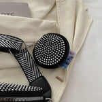 A medium-sized black crossbody bag made of PU material, adorned with metallic studs and featuring an adjustable strap.