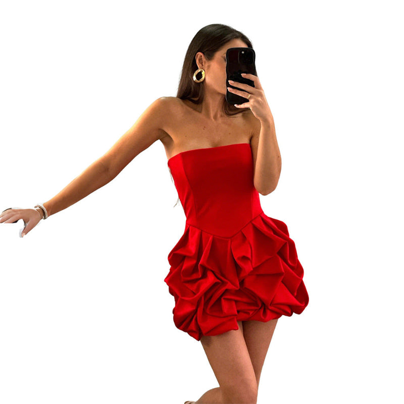 A vibrant red strapless, sleeveless mini dress with a unique one-shoulder collar and a large flower-shaped hem, made of polyester.