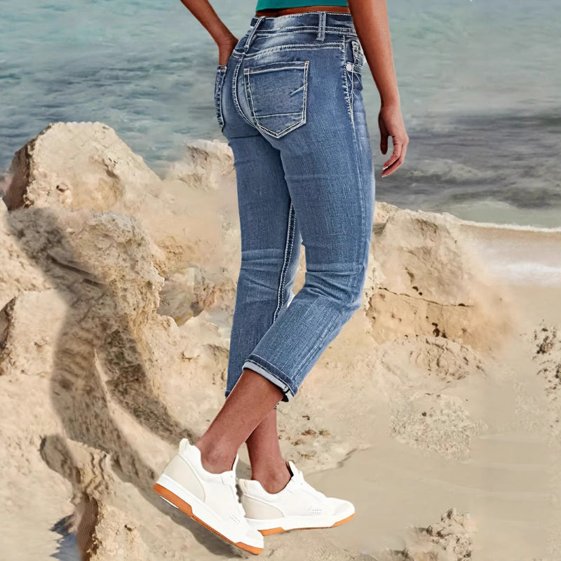 Woman wearing sky blue denim capri jeans with a flattering mid-rise fit and pocket details, standing confidently outdoors.