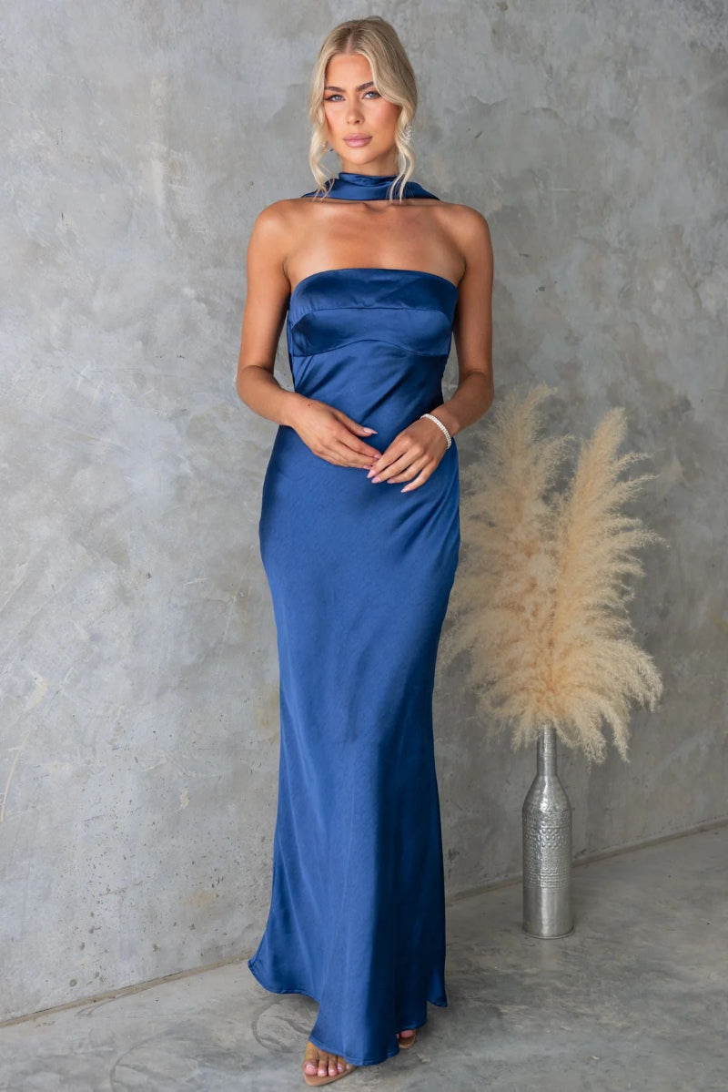 Model wears sleeveless blue hanging neck midi dress with elegant flow and high-fashion appeal