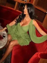 Green off-shoulder mini dress with long princess sleeves, POLO neck, high waist, lace-up detail, pleats, and an irregular hem in a solid color polyester material.