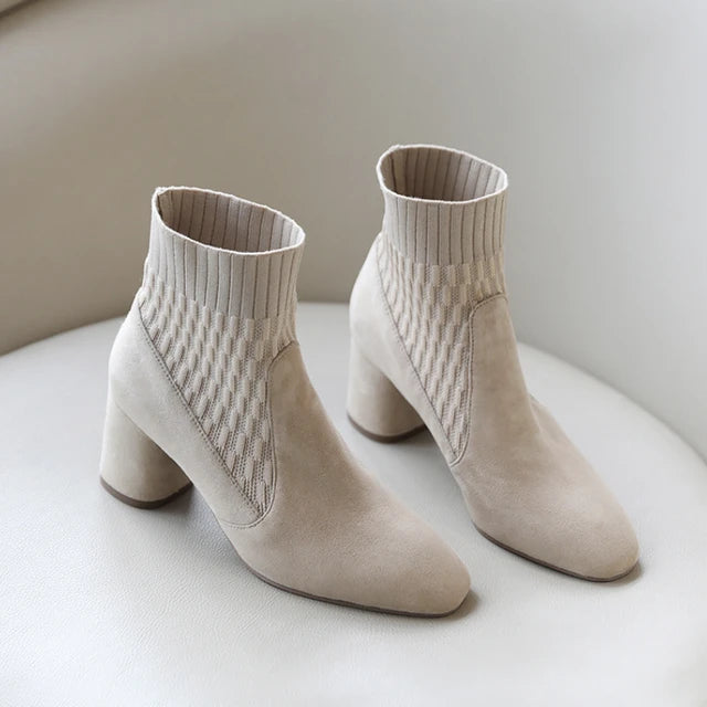  A pair of black casual lightweight ankle heel boots with a thick heel, against a neutral background