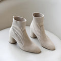  A pair of black casual lightweight ankle heel boots with a thick heel, against a neutral background