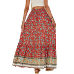 A high-waisted midi skirt with a bold digital print and a daring side slit, shown in a dark blue color. The skirt has snap buttons and is styled with a simple top.