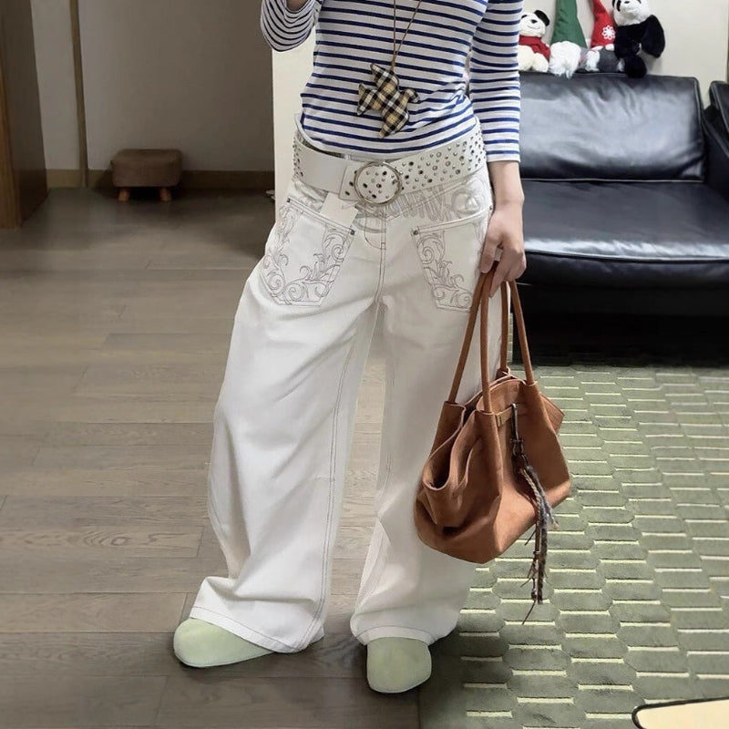 A pair of white, retro-style curved knife jeans with reverse embroidered detailing. The unique seam and leg shape are visible, highlighting the modern and edgy design.