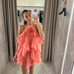 A sleeveless, strapless short dress with layered ruffles, a V-neck, and a mid-waist fit.