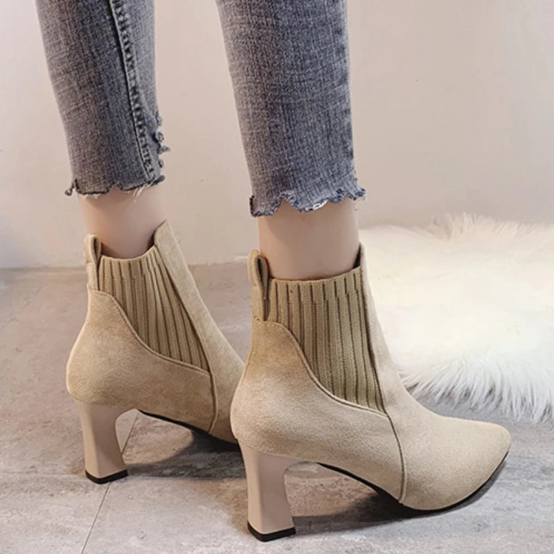 A pair of black high heel platform Martin boots with a pointed toe and thick heel.