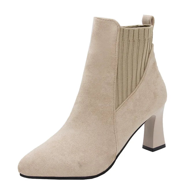 A pair of black high heel platform Martin boots with a pointed toe and thick heel.