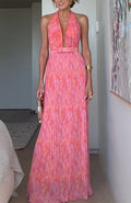 A woman from behind wearing a pink, backless, sleeveless midi dress with V-lace detailing on the back.