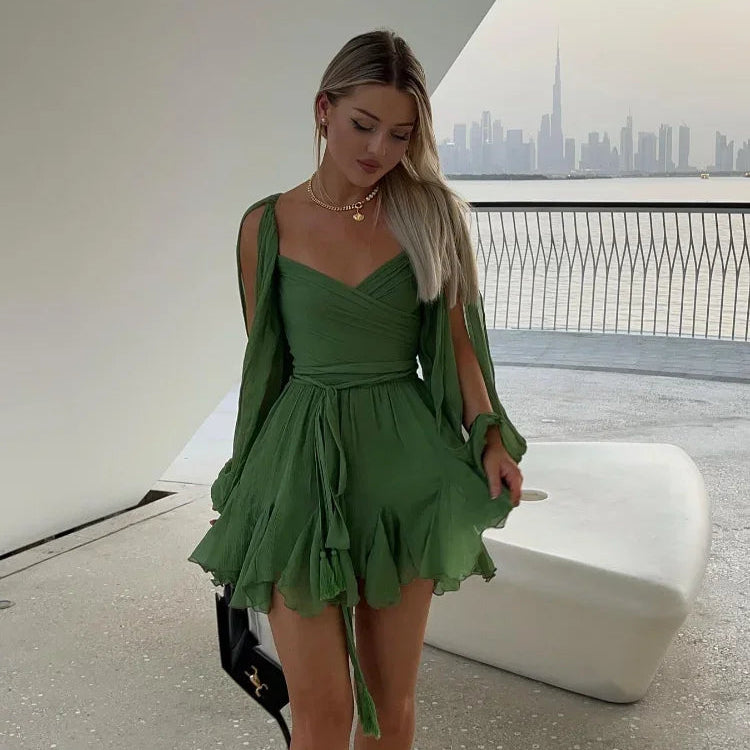 Green off-shoulder mini dress with long princess sleeves, POLO neck, high waist, lace-up detail, pleats, and an irregular hem in a solid color polyester material.
