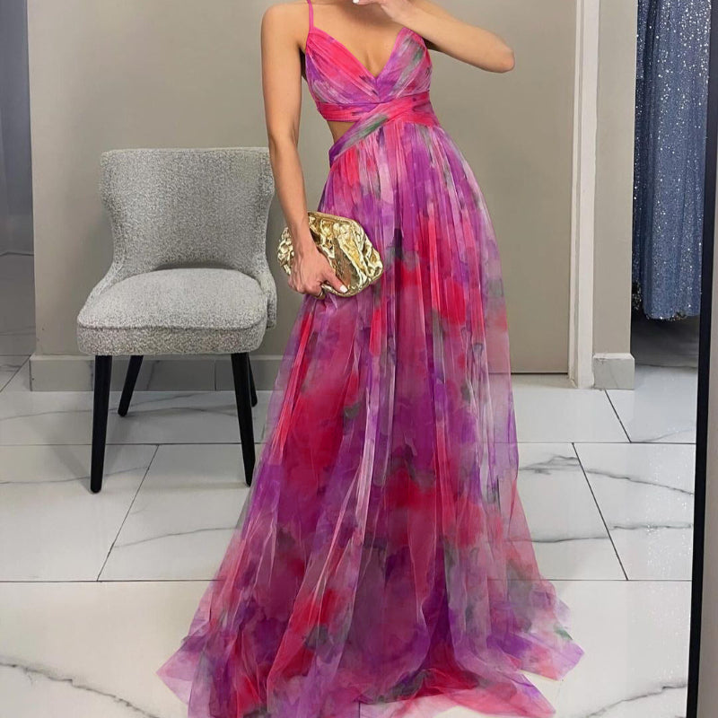Woman wearing a strapless maxi dress with vibrant abstract print, holding gold clutch