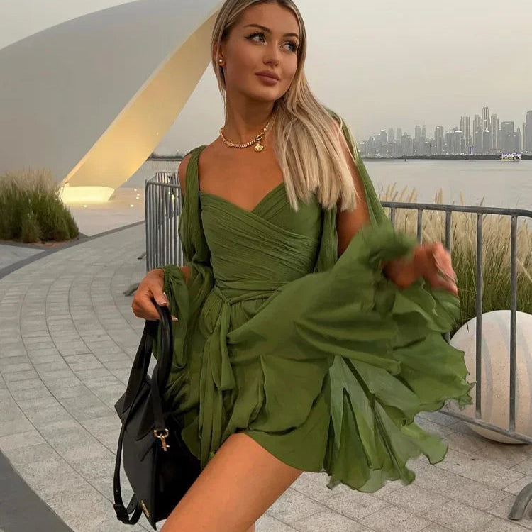Green off-shoulder mini dress with long princess sleeves, POLO neck, high waist, lace-up detail, pleats, and an irregular hem in a solid color polyester material.