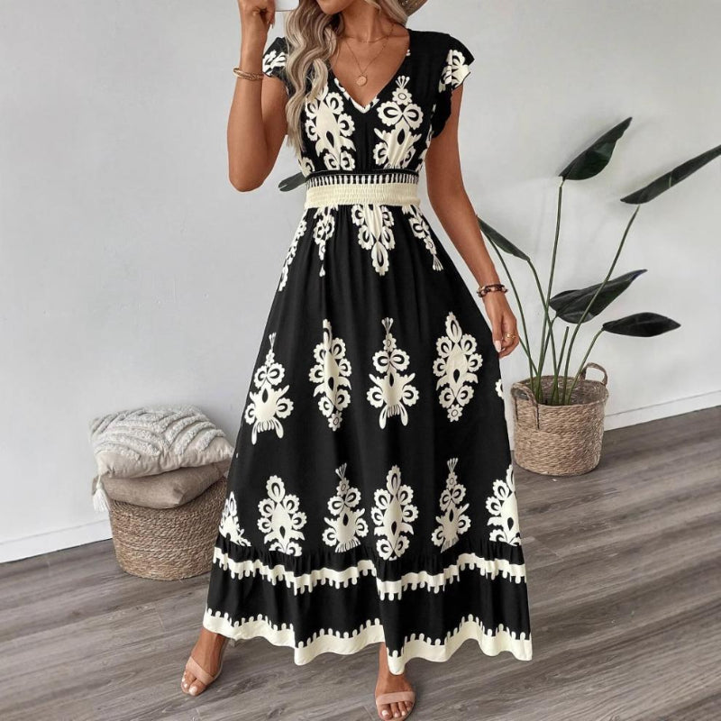 A stylish model wearing an elegant floral V-neck midi dress in a dark blue color. The dress has a waist-cinched design and a beautiful positional flower pattern, perfect for an elegant commuting style.