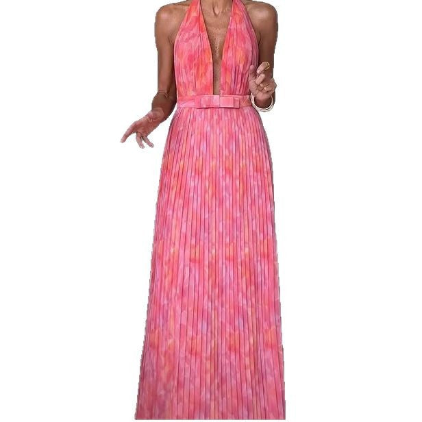 A woman from behind wearing a pink, backless, sleeveless midi dress with V-lace detailing on the back.