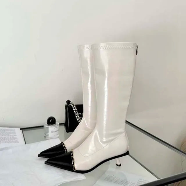 A pair of elegant women's knee-high boots with a pointed toe and thin heel, shown in both black and apricot colors.