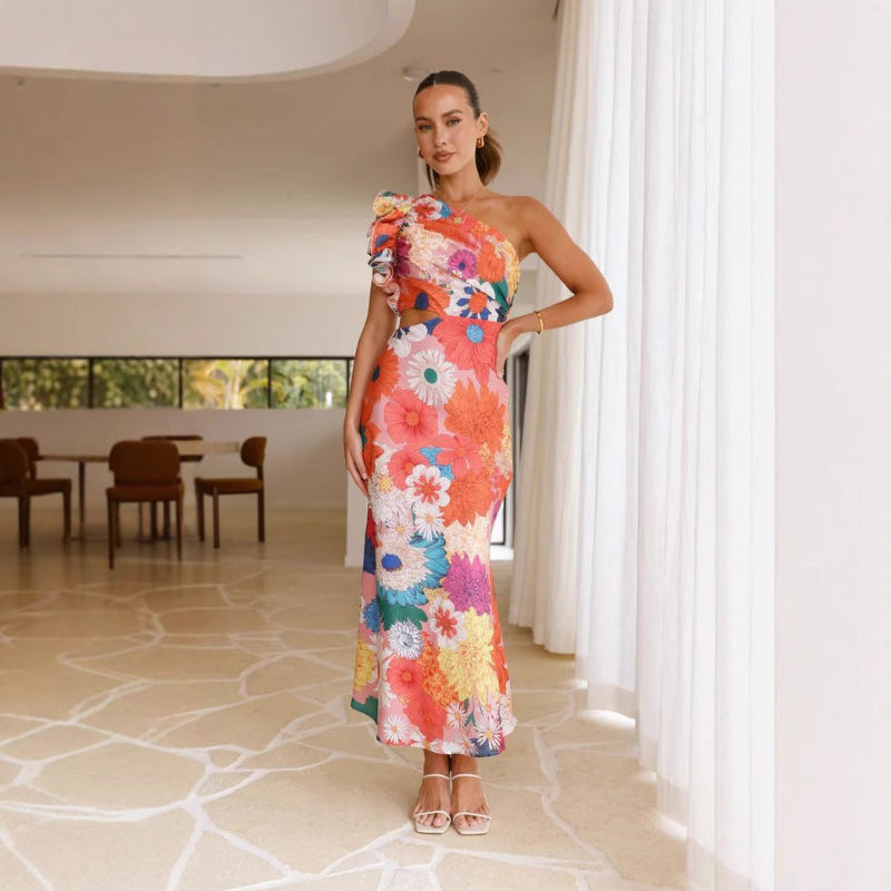 A fitted, one-shoulder maxi dress with a V-neck and sleeveless design, available in green, yellow, rose pink, red, and black, suitable for resort wear.