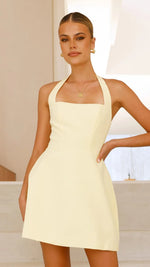 A model wearing a solid color short halter dress with a one-shoulder design.
