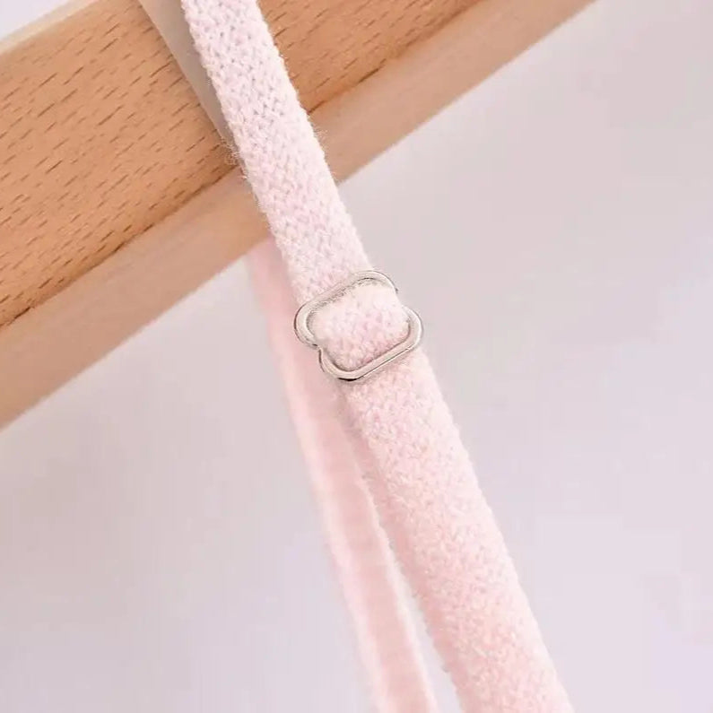 A sleeveless, V-neck, A-line mini dress in a criss-cross knitted pattern, adorned with floral appliques, available in pink and white, with a backless design.