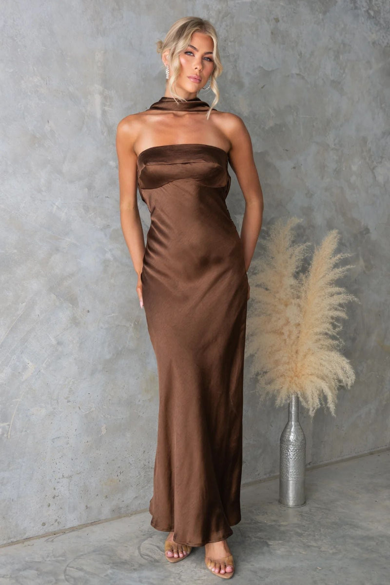 Model wears sleeveless blue hanging neck midi dress with elegant flow and high-fashion appeal