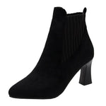 A pair of black high heel platform Martin boots with a pointed toe and thick heel.