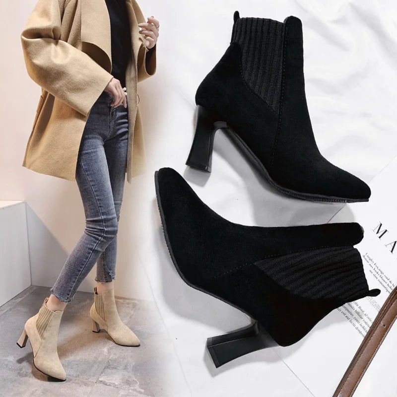 A pair of black high heel platform Martin boots with a pointed toe and thick heel.