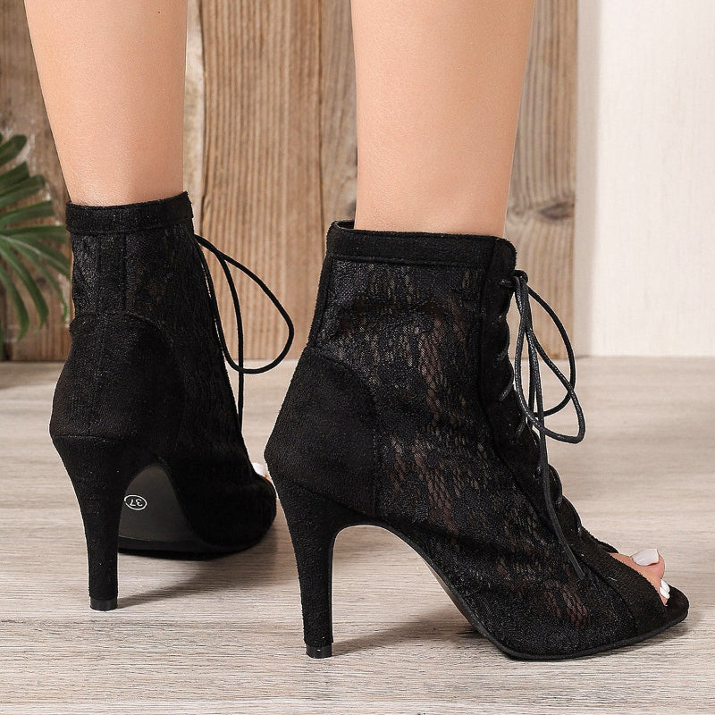 A pair of black, ultra-high, slim high-heeled mesh sandal boots with a fish-mouth toe.