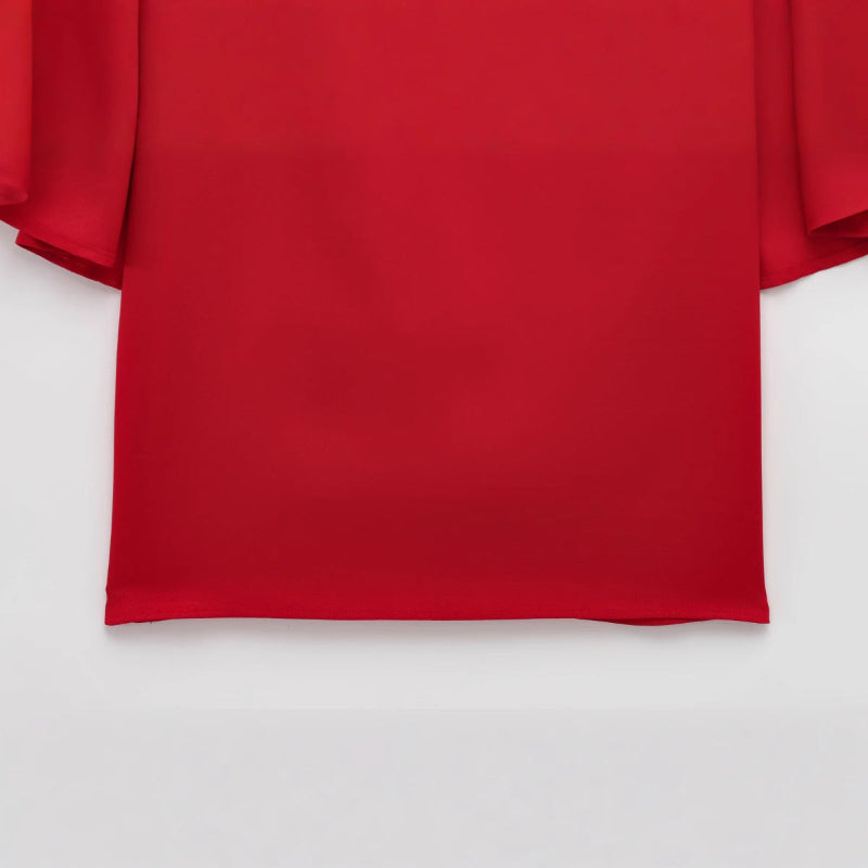 This short dress features a bold, loose cape design that makes a striking statement with effortless style.