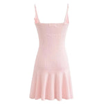 A sleeveless, V-neck, A-line mini dress in a criss-cross knitted pattern, adorned with floral appliques, available in pink and white, with a backless design.