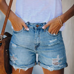A pair of light blue, mid-waist denim shorts with a straight-leg, wide-leg fit. The shorts feature ripped and distressed details, showcasing a casual street-style look.
