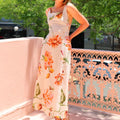 A model wearing a floral patterned, long, backless, and strapless midi dress, suitable for office wear.