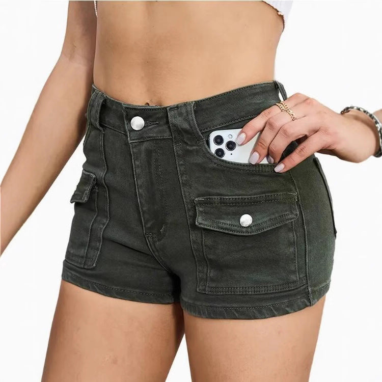 Model wearing high-waisted khaki denim shorts in street style setting, casual look with sleeveless top.