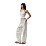 A pair of white, retro-style curved knife jeans with reverse embroidered detailing. The unique seam and leg shape are visible, highlighting the modern and edgy design.