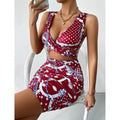 A close-up shot of a person wearing a wine red, floral-printed, short-skirt dress. The dress has thin shoulder straps that cross over a high-waisted, fitted back.
