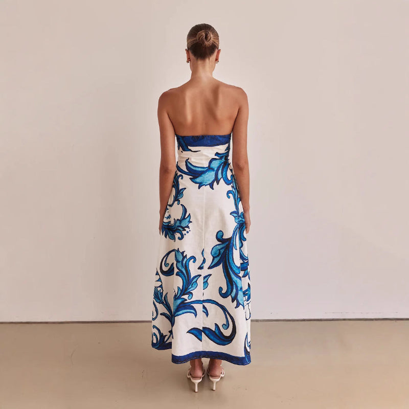 A model wearing a slim-fit, strapless, printed midi dress with a one-shoulder collar, suitable for casual wear.
