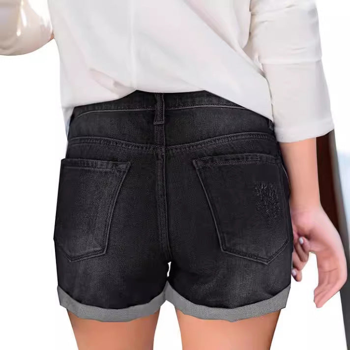 A pair of black, distressed denim shorts with a cuffed hem. The shorts have a loose fit and a mid-rise waist, showcasing a casual yet stylish look.