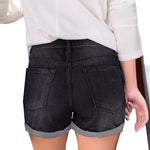 A pair of black, distressed denim shorts with a cuffed hem. The shorts have a loose fit and a mid-rise waist, showcasing a casual yet stylish look.