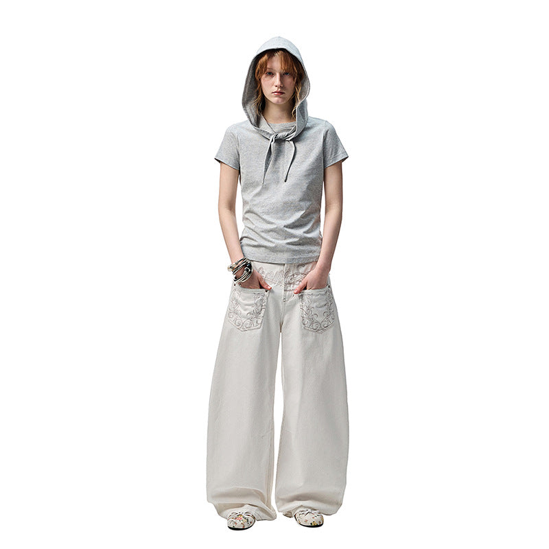 A pair of white, retro-style curved knife jeans with reverse embroidered detailing. The unique seam and leg shape are visible, highlighting the modern and edgy design.