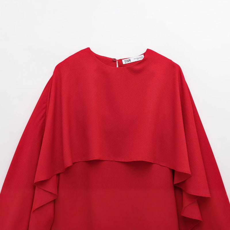 This short dress features a bold, loose cape design that makes a striking statement with effortless style.