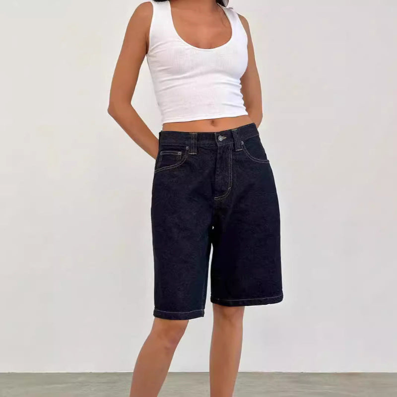 A pair of dark blue, mid-length, vintage-style denim shorts with a distressed finish. The shorts are laid flat, showcasing the straight-leg cut and medium-rise waist.