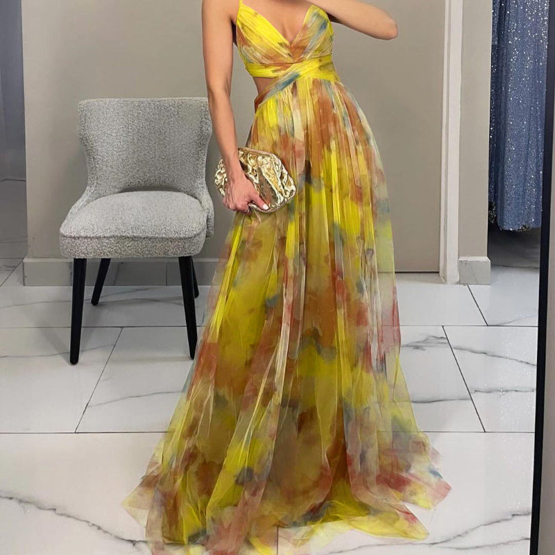 Woman wearing a strapless maxi dress with vibrant abstract print, holding gold clutch