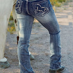A pair of dark blue, high-waist, straight-leg denim jeans with subtle embroidery and a tie-dye gradient effect. The jeans are displayed flat, showcasing the style and texture.