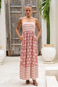 A sleeveless, high-waisted, midi-length dress with a printed pattern and a one-shoulder, backless design, photographed on a white background.