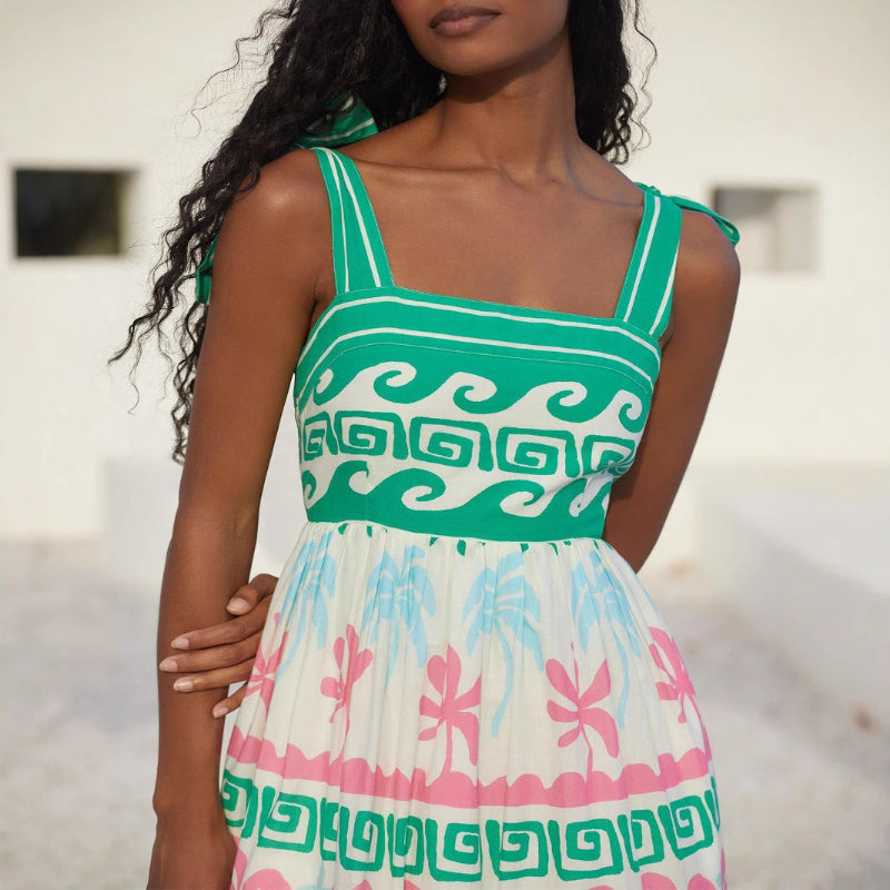 A green, sleeveless, one-shoulder bandage midi dress with bow tie suspenders, shown on a mannequin from the front.
