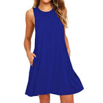 Une robe midi trapèze sans manches à col en V de couleur unie, fabriquée dans un matériau mélangé, avec un détail d'épaule dénudée, portée de manière décontractée.