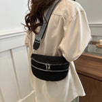 A medium-sized black crossbody bag made of PU material, adorned with metallic studs and featuring an adjustable strap.