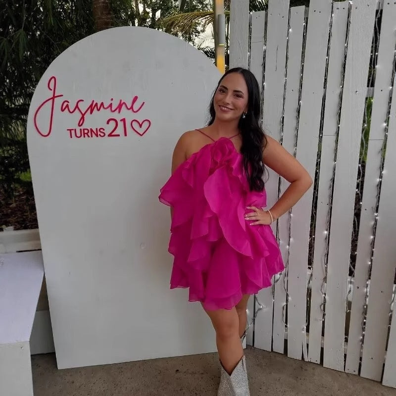 A sleeveless, strapless short dress with layered ruffles, a V-neck, and a mid-waist fit.