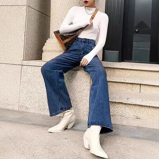 Woman wearing slim high-waisted light blue non-stretch denim jeans with a tucked-in blouse in a cityscape.