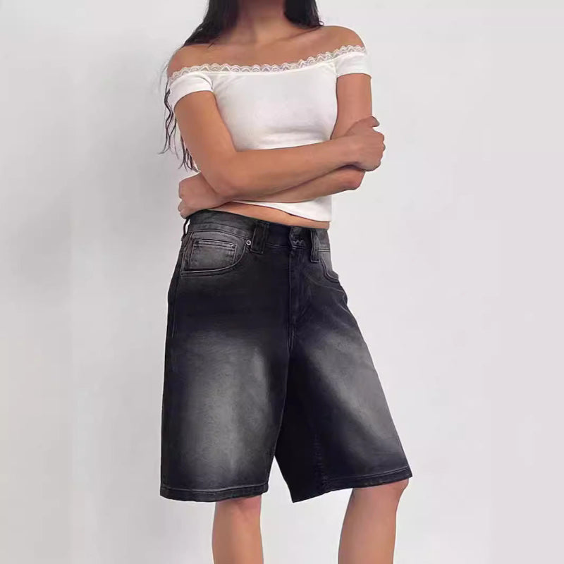 A pair of dark blue, mid-length, vintage-style denim shorts with a distressed finish. The shorts are laid flat, showcasing the straight-leg cut and medium-rise waist.